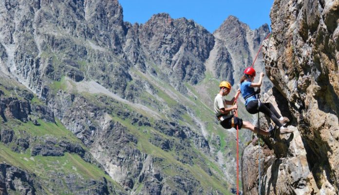 Zwei Bergsteiger klettern an einem steilen Felsabhang