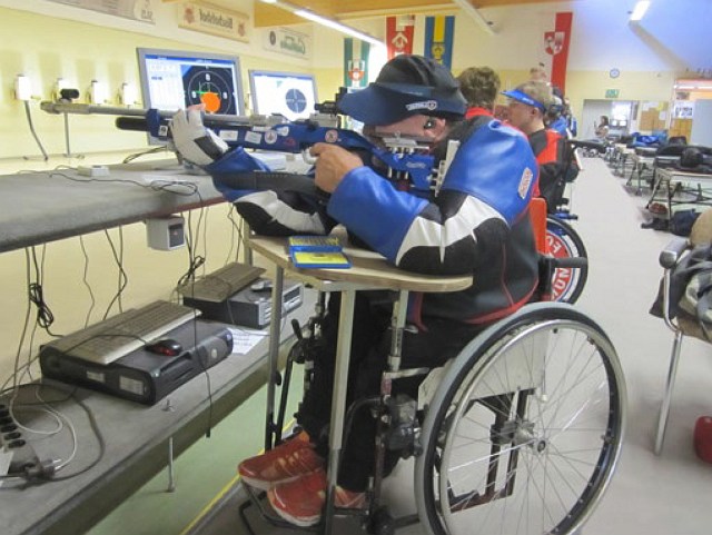 Ein Rollstuhlfahrer im Liegenanschlag mit dem Luftgewehr.