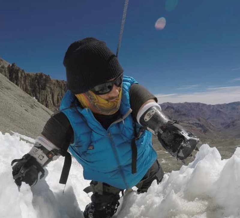 Kyle Maynard kämpft sich in Winterausrüstung durch Eis und Schnee einen Berg hoch