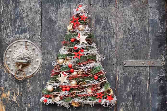 Ein Deko-Weihnachtsbaum an einer alten Holztür.