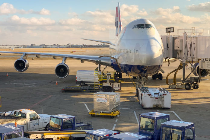 Flugzeug auf dem Flughafen mit Gepäckfahrzeugen im Vordergrund