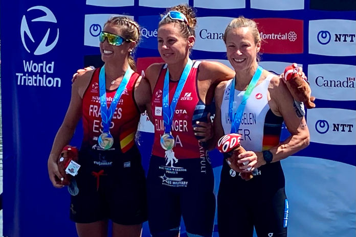 Drei Frauen stehen auf einem Podium bei einer Siegerehrung und haben Medaillen um den den Hals