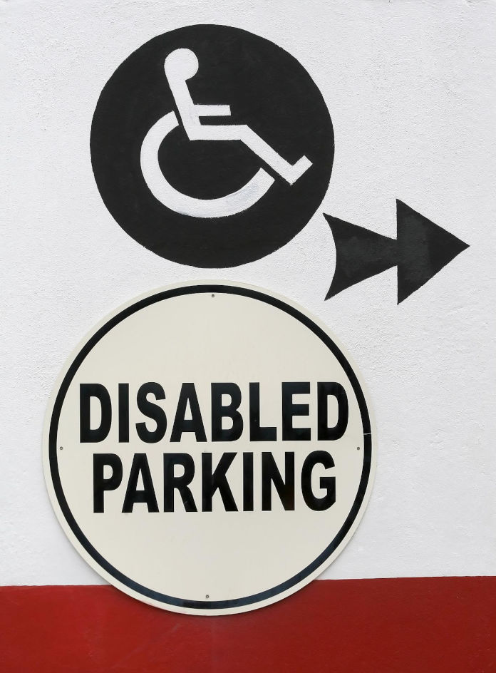 Ein Schild, auf dem Disabled Parking steht, mit einem Zeichen für Rollstuhlfahrer versehen
