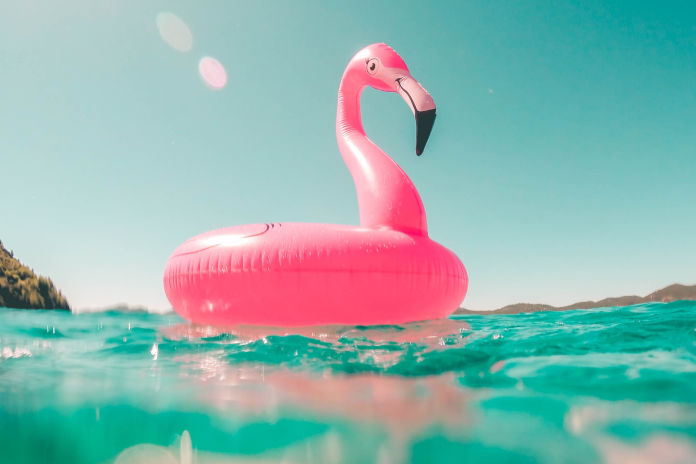 Ein Wasserspielzeug in Form eines Flamingos auf einer Wasseroberfläche.