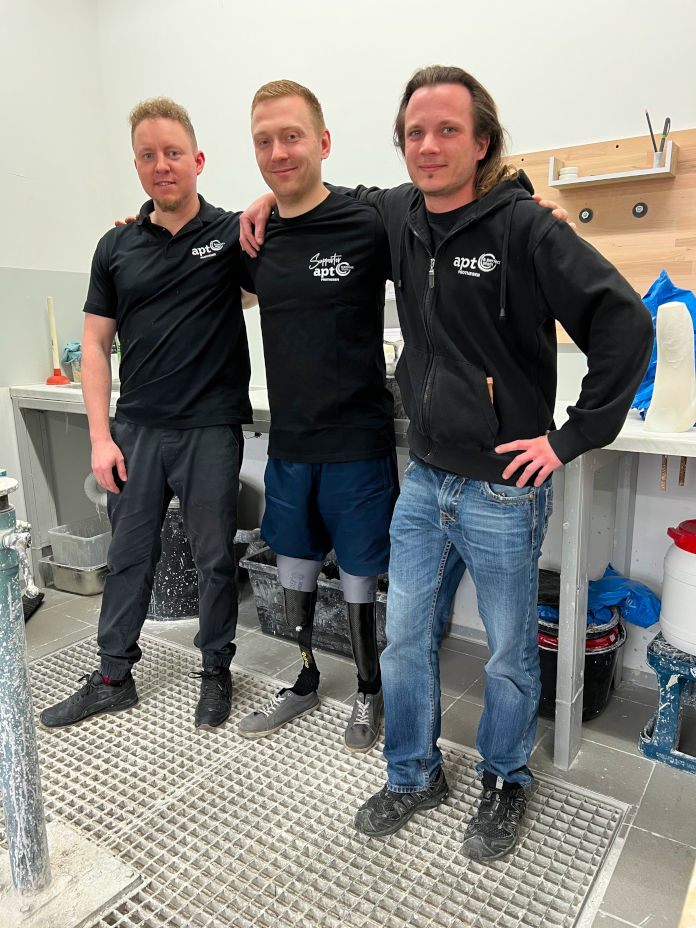 Drei Männer in einer Orthopädie-Technik-Werkstatt. 