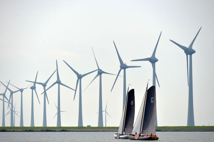 Auf einem Gewässer in Holland. Zwei Segelboote. Im Hintergrund mehrere Windmühlen.