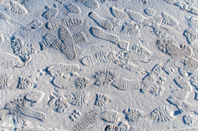 Viele verschiedene Schuhabdrücke im Schnee