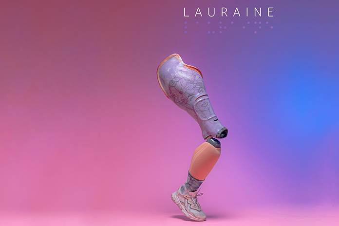 Eine Beinprothese mit einem Sportschuh. Der Hintergrund des Bildes ist in rosé blau Tönen gehalten.