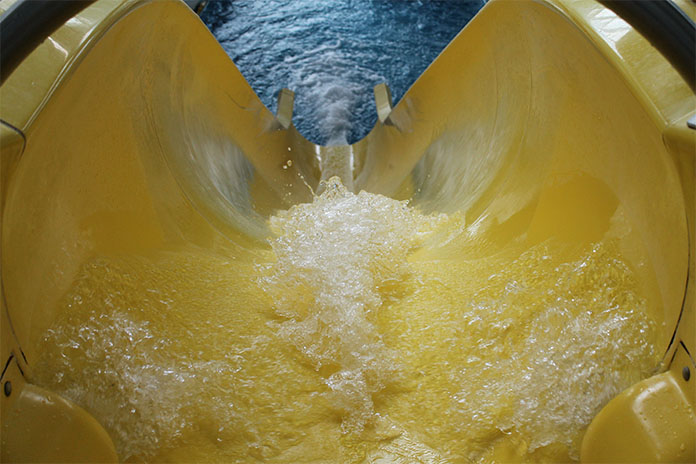 Eine von oben fotografierte gelbe, steile Wasserrutsche.