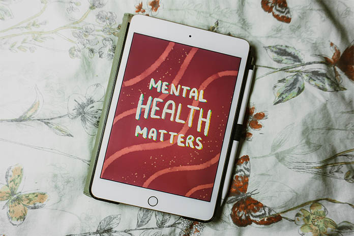 Ein Tablet auf einer Bettdecke mit einem Stift an der Seite, auf dem auf rotem Hintergrund steht: Mental Health Matters. 